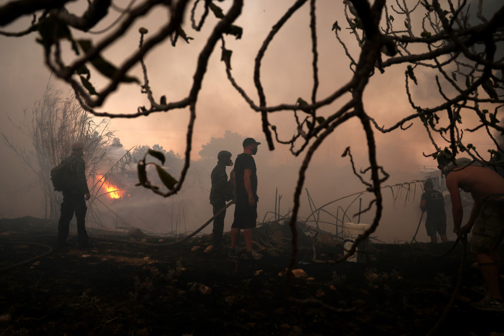 ATHENS, GREECE - AUGUST 12: People try to extinguish a wildfire in Nea Penteli near Athens, Greece, on August 12, 2024. (Photo by Costas Baltas/Anadolu via Getty Images)